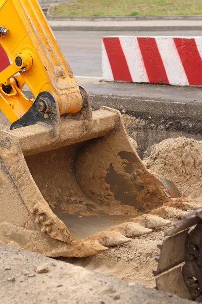 Kazı kovasına yakın çekim. Kazı makinesi araziyi düzleştiriyor. Şehirdeki tamirat işleri. Özel ekipmanlar. Sanayi, inşaat ve şehir projeleri. İnşaat alanındaki ekipman.