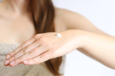 El kremi. Genç bir kadının eline nemlendirici kremle yakın çekim. Cilt bakımı. Cilde krem süren kadın ellerinin yakın çekimi. Sağlıklı cilt, cilt bakımı konsepti. Kozmetoloji. Günlük rutin