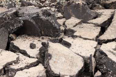 Asfalt yolda büyük parçalara ayrıldı. Şehirdeki tamirat işleri. Yol onarımı. Asfalt kaldırımlardan oluşan bir dağ. Tamir konsepti. Bir asfalt enkazı yığını. Yakın plan.