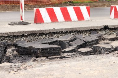 Asfalt yolda büyük parçalara ayrıldı. Şehirdeki tamirat işleri. Yol onarımı. Asfalt kaldırımlardan oluşan bir dağ. Tamir konsepti. Bir asfalt enkazı yığını. Yakın plan.