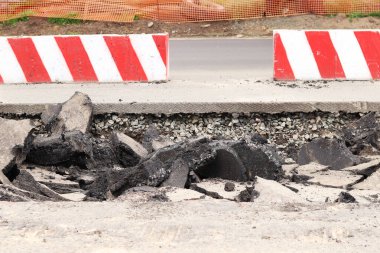 Asfalt yolda büyük parçalara ayrıldı. Şehirdeki tamirat işleri. Yol onarımı. Asfalt kaldırımlardan oluşan bir dağ. Tamir konsepti. Bir asfalt enkazı yığını. Yakın plan.