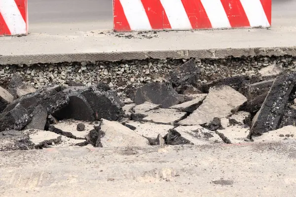 Asfalt yolda büyük parçalara ayrıldı. Şehirdeki tamirat işleri. Yol onarımı. Asfalt kaldırımlardan oluşan bir dağ. Tamir konsepti. Bir asfalt enkazı yığını. Yakın plan.