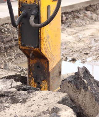 Çalışan bir kaya matkabının yakın çekimi. Hidrolik çekiç. Ekipman. Yol tamiri için hidrolik çekiç. Bir kazıcıya hidrolik matkap monte edilmiş. İnşaat alanında ağır ekipman parçaları.