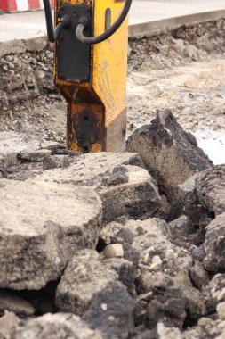 Çalışan bir kaya matkabının yakın çekimi. Hidrolik çekiç. Ekipman. Yol tamiri için hidrolik çekiç. Bir kazıcıya hidrolik matkap monte edilmiş. İnşaat alanında ağır ekipman parçaları.
