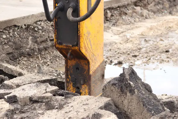 Çalışan bir kaya matkabının yakın çekimi. Hidrolik çekiç. Ekipman. Yol tamiri için hidrolik çekiç. Bir kazıcıya hidrolik matkap monte edilmiş. İnşaat alanında ağır ekipman parçaları.