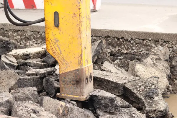 Çalışan bir kaya matkabının yakın çekimi. Hidrolik çekiç. Ekipman. Yol tamiri için hidrolik çekiç. Bir kazıcıya hidrolik matkap monte edilmiş. İnşaat alanında ağır ekipman parçaları.