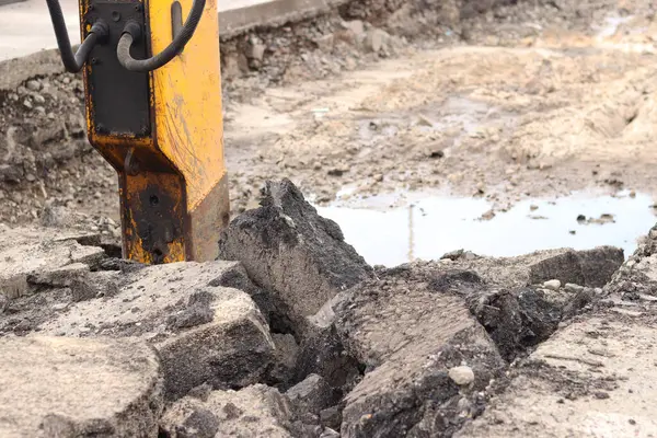 Çalışan bir kaya matkabının yakın çekimi. Hidrolik çekiç. Ekipman. Yol tamiri için hidrolik çekiç. Bir kazıcıya hidrolik matkap monte edilmiş. İnşaat alanında ağır ekipman parçaları.