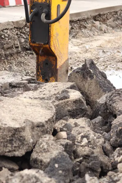 Çalışan bir kaya matkabının yakın çekimi. Hidrolik çekiç. Ekipman. Yol tamiri için hidrolik çekiç. Bir kazıcıya hidrolik matkap monte edilmiş. İnşaat alanında ağır ekipman parçaları.