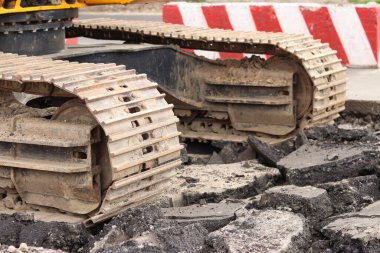 Kazı hattını kapatın. İnşaat kazıcısının bir kısmına yakın çekim, takip aracı. Şehirdeki tamirat işleri. Özel ekipman. İnşaat alanındaki ekipman. Ağır inşaat ekipmanları