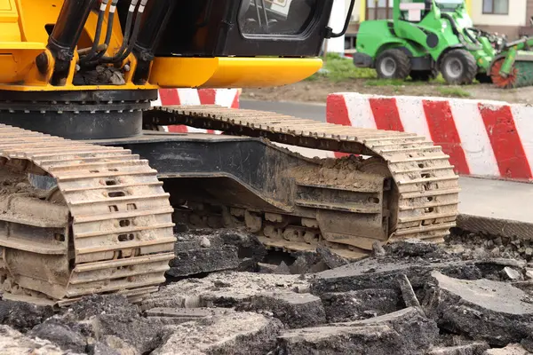 Kazı hattını kapatın. İnşaat kazıcısının bir kısmına yakın çekim, takip aracı. Şehirdeki tamirat işleri. Özel ekipman. İnşaat alanındaki ekipman. Ağır inşaat ekipmanları