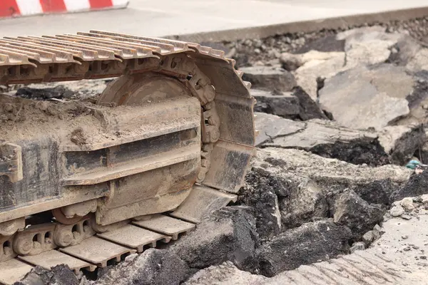 Kazı hattını kapatın. İnşaat kazıcısının bir kısmına yakın çekim, takip aracı. Şehirdeki tamirat işleri. Özel ekipman. İnşaat alanındaki ekipman. Ağır inşaat ekipmanları