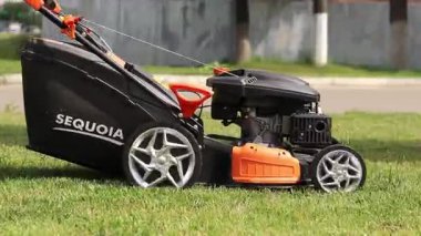 Kyiv, Ukrayna - 31 Mayıs 2025: Çim biçme makinesi yakın plan. Çim biçme makinesiyle çimleri biçen bir işçi. Bahçe bakımı servisi. Ekipman. Mevsimlik iş