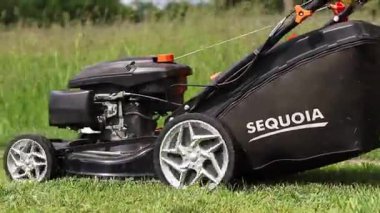 Kyiv, Ukrayna - 31 Mayıs 2025: Çim biçme makinesi yakın plan. Çim biçme makinesiyle çimleri biçen bir işçi. Bahçe bakımı servisi. Ekipman. Mevsimlik iş