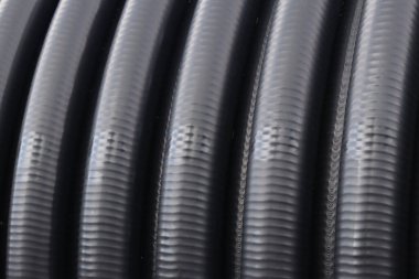 Drenaj borusu. Su kaynağı ya da kanalizasyon için siyah plastik borular, yakın plan. Açık havada borular var. Su tedarik sisteminin kurulumu ya da onarımı. Şehirdeki tamirat işleri.