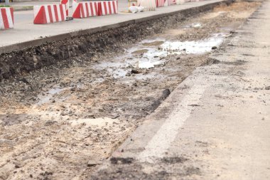 Şehirde yol tamiri, asfalt şeritleri. Açık havada yol tamiri bölümü. Yol yenileme, derin çukur. Özelleştirilmiş bölüm