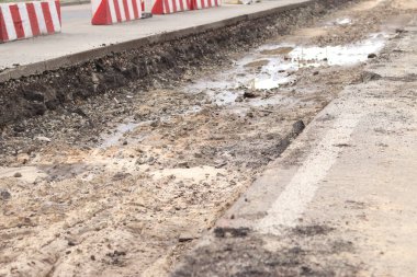 Şehirde yol tamiri, asfalt şeritleri. Açık havada yol tamiri bölümü. Yol yenileme, derin çukur. Özelleştirilmiş bölüm