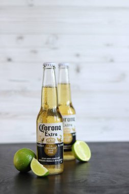 Kyiv, Ukrayna - 10 Mayıs 2025: Corona Ekstra limonlu bira, ahşap arka planda bira. Corona hafif bir bira. Limonlu şişe bira, yan görüş, boş yer. Tazeleyici içecek.