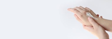 El kremi. Genç bir kadının ellerinin nemlendirici kremle yakın çekimi. Cilt bakımı. Ellerine krem süren bir kadın, hafif arka plan. Sağlıklı cilt. Kozmetoloji. Günlük rutin