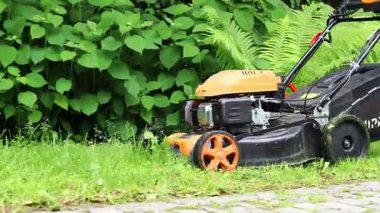 Kyiv, Ukrayna - Haziran 06, 2025: Çim biçme makinesi yakın plan. Çim biçme makinesiyle çim biçen bir işçi. Bahçe bakımı servisi. Ekipman. Mevsimlik iş