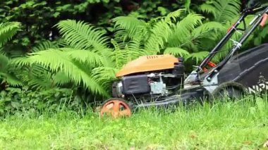 Kyiv, Ukrayna - Haziran 06, 2025: Çim biçme makinesi yakın plan. Çim biçme makinesiyle çim biçen bir işçi. Bahçe bakımı servisi. Ekipman. Mevsimlik iş