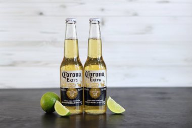 Kyiv, Ukrayna - 10 Mayıs 2025: Corona Ekstra limonlu bira, açık ahşap arka planda bira. Corona hafif bir bira. Limonlu şişe bira, yan görüş, boş yer. Tazeleyici içecek.