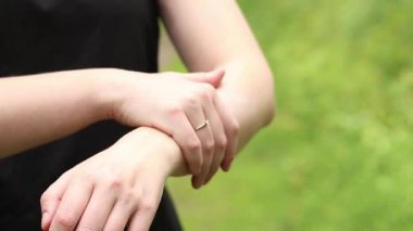 Sivrisinek kovucu kullanan bir kız. Sivrisinek, kene ve diğer böcek kovucuyu cilde sürten kadın ellerine yakın çekim. Açık hava eğlencesi. Böcek koruması. Yazın ormanda yürürken