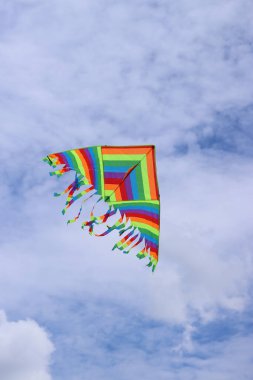 Bulutlu gökyüzüne karşı parlak uçurtma. Çocuklar ve yetişkinler için oyuncak. Açık hava aktiviteleri. Gökyüzünde renkli uçurtma uçar, rüzgarlı bir havada. Bulutsuz bir ruh hali. Uç! Parlak renkli uçurtma havada uçuşuyor.