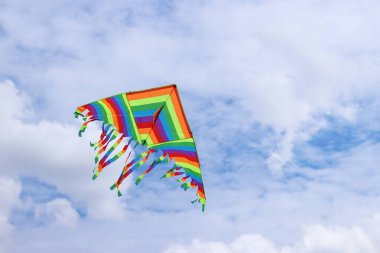 Bulutlu gökyüzüne karşı parlak uçurtma. Çocuklar ve yetişkinler için oyuncak. Açık hava aktiviteleri. Gökyüzünde renkli uçurtma uçar, rüzgarlı bir havada. Bulutsuz bir ruh hali. Uç! Parlak renkli uçurtma havada uçuşuyor.
