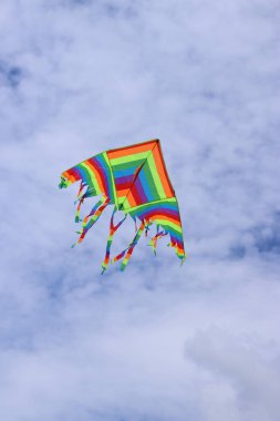 Bulutlu gökyüzüne karşı parlak uçurtma. Çocuklar ve yetişkinler için oyuncak. Açık hava aktiviteleri. Gökyüzünde renkli uçurtma uçar, rüzgarlı bir havada. Bulutsuz bir ruh hali. Uç! Parlak renkli uçurtma havada uçuşuyor.