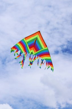 Bulutlu gökyüzüne karşı parlak uçurtma. Çocuklar ve yetişkinler için oyuncak. Açık hava aktiviteleri. Gökyüzünde renkli uçurtma uçar, rüzgarlı bir havada. Bulutsuz bir ruh hali. Uç! Parlak renkli uçurtma havada uçuşuyor.