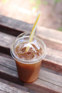 Karışık kahve. Tek kullanımlık plastik bardakta meyve suyu ve pipetli kahve. Portakal suyu, şurup ve buzlu kahve. İçkileri tazeleyip, yayalar için sıcak havada dinlenmek. Hazır içecek, yakın plan.