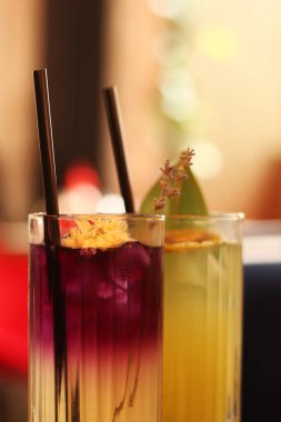 Cam bardaklarda nefis limonatalar. Kafede ya da restoranda içkileri tazeliyorum. Lavanta ve limonata yakın plan. Lezzetli parlak içeceklerle dolu cam bardaklar. Pipetle kokteyl. Buzlu içecekler
