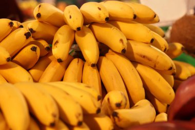 Olgun muzlar birikti. Süpermarkette satılan sarı muzlar. Yiyecekler. Bakkal geçmişi. Sokak pazarında bir sürü olgun muz. Mini ya da bebek muzları yaklaşın