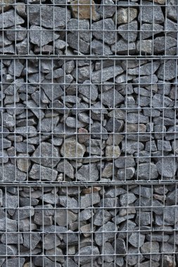 Galvanize ağ içinde harabe taşı. Geçmişi. Duvarları örmek için taşlardan örülmüş Gabion şiltesi. Ağlı taşlar, dekoratif duvarlar, güçlendirme