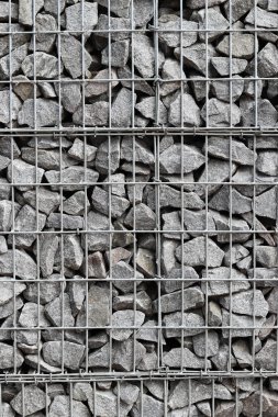 Galvanize ağ içinde harabe taşı. Geçmişi. Duvarları örmek için taşlardan örülmüş Gabion şiltesi. Ağlı taşlar, dekoratif duvarlar, güçlendirme