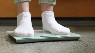 Ağırlık kontrolü için zemin ölçekleri. Kadın ayaklarının zemin terazisinde durduğu yakın plan. Ağırlık. Kilo kaybı, diyet ve sağlıklı yaşam tarzı kavramı. Elektronik terazide duran kadın ayaklarının yakın çekimi