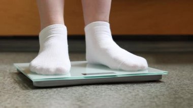 Ağırlık kontrolü için zemin ölçekleri. Kadın ayaklarının zemin terazisinde durduğu yakın plan. Ağırlık. Kilo kaybı, diyet ve sağlıklı yaşam tarzı kavramı. Elektronik terazide duran kadın ayaklarının yakın çekimi