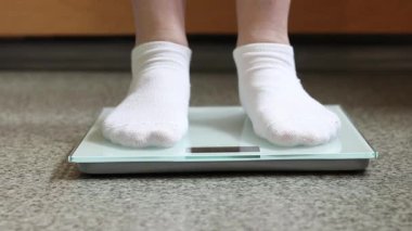 Ağırlık kontrolü için zemin ölçekleri. Kadın ayaklarının zemin terazisinde durduğu yakın plan. Ağırlık. Kilo kaybı, diyet ve sağlıklı yaşam tarzı kavramı. Elektronik terazide duran kadın ayaklarının yakın çekimi