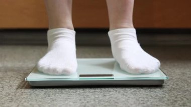 Ağırlık kontrolü için zemin ölçekleri. Kadın ayaklarının zemin terazisinde durduğu yakın plan. Ağırlık. Kilo kaybı, diyet ve sağlıklı yaşam tarzı kavramı. Elektronik terazide duran kadın ayaklarının yakın çekimi