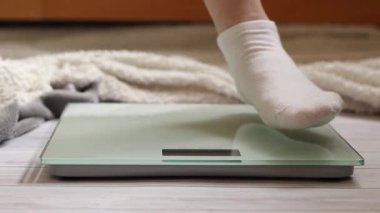 Ağırlık kontrolü için zemin ölçekleri. Kadın ayaklarının zemin terazisinde durduğu yakın plan. Ağırlık. Kilo kaybı, diyet ve sağlıklı yaşam tarzı kavramı. Elektronik terazide duran kadın ayaklarının yakın çekimi
