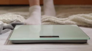 Ağırlık kontrolü için zemin ölçekleri. Kadın ayaklarının zemin terazisinde durduğu yakın plan. Ağırlık. Kilo kaybı, diyet ve sağlıklı yaşam tarzı kavramı. Elektronik terazide duran kadın ayaklarının yakın çekimi