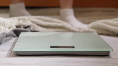 Ağırlık kontrolü için zemin ölçekleri. Kadın ayaklarının zemin terazisinde durduğu yakın plan. Ağırlık. Kilo kaybı, diyet ve sağlıklı yaşam tarzı kavramı. Elektronik terazide duran kadın ayaklarının yakın çekimi