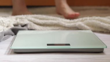 Ağırlık kontrolü için zemin ölçekleri. Kadın ayaklarının zemin terazisinde durduğu yakın plan. Ağırlık. Kilo kaybı, diyet ve sağlıklı yaşam tarzı kavramı. Elektronik terazide duran kadın ayaklarının yakın çekimi