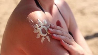Güneş kremiyle boyanmış bir kadın derisi. Yaz, sahil, bronzlaşma. Plajda mayo giyen bir kadın. Krem cildi güneşten, bronzlaşmadan ve omuz kreminden korur.