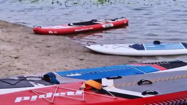 Kyiv, Ukrayna - 27 Temmuz 2025: Suda yüzmek ve nehir kıyısında kayak yapmak için SUP tahtaları. Yazın aktif bir eğlence. Kano ve SUP turist rotası, hobi ve su sporları için kiralıyorlar.