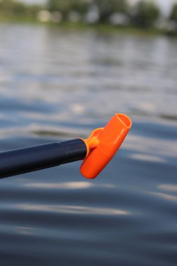 Stand-up pedal sapı, yakın çekim. Yaz tatili için aktif bir yol. Aktif yaz tatili. Su sporları. Suyun, nehrin arka planında hafif plastik kürek