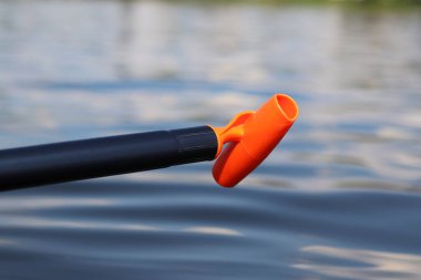 Stand-up pedal sapı, yakın çekim. Yaz tatili için aktif bir yol. Aktif yaz tatili. Su sporları. Suyun, nehrin arka planında hafif plastik kürek