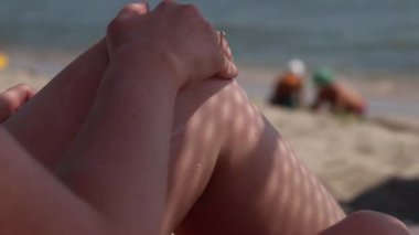 Cilde güneş kremi sürerken yaklaş. SPF koruması. Dişi el güneş ışınlarının saldırgan etkilerinden korunmak için cilde SPF kremi sürer. Plaj tatili Güvenli bronzlaşma