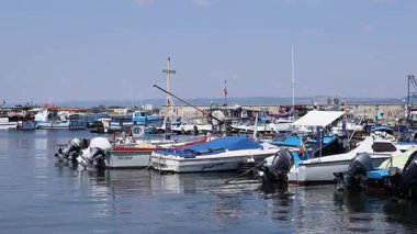 Nesebar, Bulgaristan - 25 Ağustos 2025: Bir sürü küçük teknesi olan deniz iskelesi. Sakin sulara demirlemiş tekneleri olan bir liman. Karadeniz kıyısında sudaki sürat tekneleri. Deniz kenarı manzarası