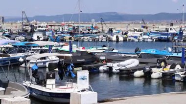 Nesebar, Bulgaristan - 25 Ağustos 2025: Bir sürü küçük teknesi olan deniz iskelesi. Sakin sulara demirlemiş tekneleri olan bir liman. Karadeniz kıyısında sudaki sürat tekneleri. Deniz kenarı manzarası